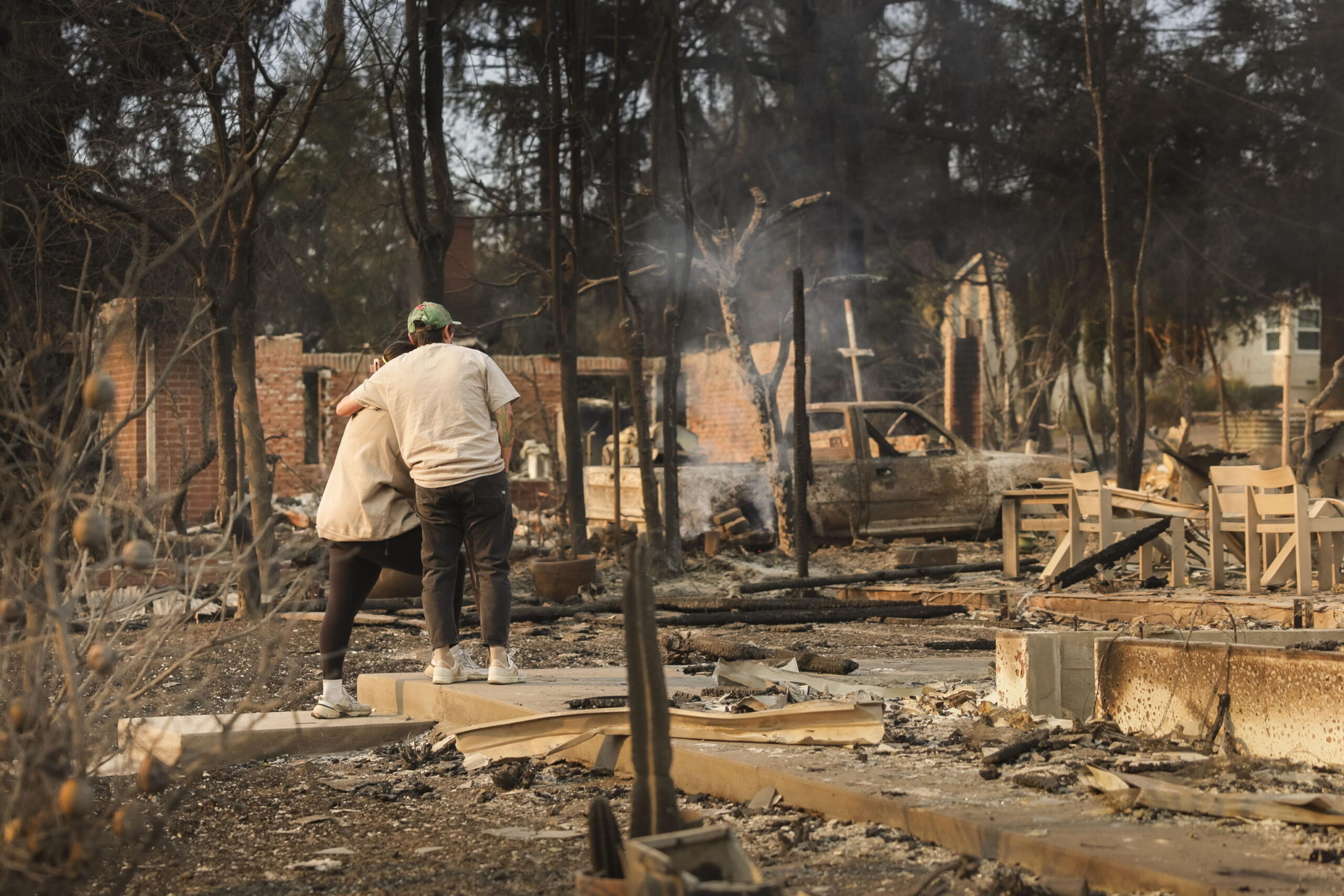 La foto del giorno, la coppia abbracciata davanti alle macerie della loro casa distrutta negli incendi di Los Angeles