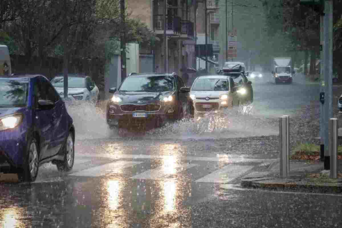 Auto passano su una strada allagata per la pioggia 