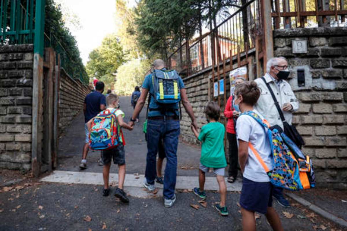 genitore con figli all'entrata di scuola