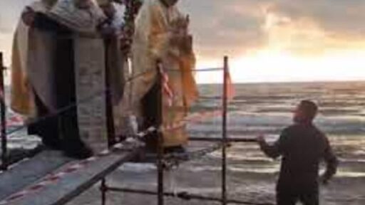 Il pope della chiesa ortodossa di Torvaianica cade in mare durante il lancio della croce VIDEO