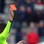 Dettaglio del braccio di un arbitro che esibisce un cartellino rosso