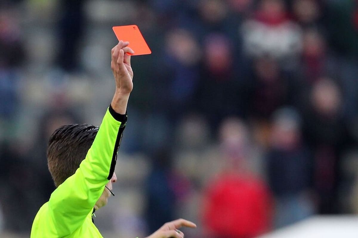 Dettaglio del braccio di un arbitro che esibisce un cartellino rosso