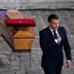 Macron, presidente della Francia, davanti a una bara