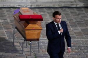 Macron, presidente della Francia, davanti a una bara