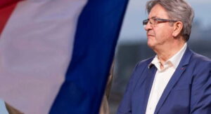 Jean Luc Melenchon davanti a una bandiera della Francia