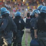 Polizia in tenuta antisommossa in campo