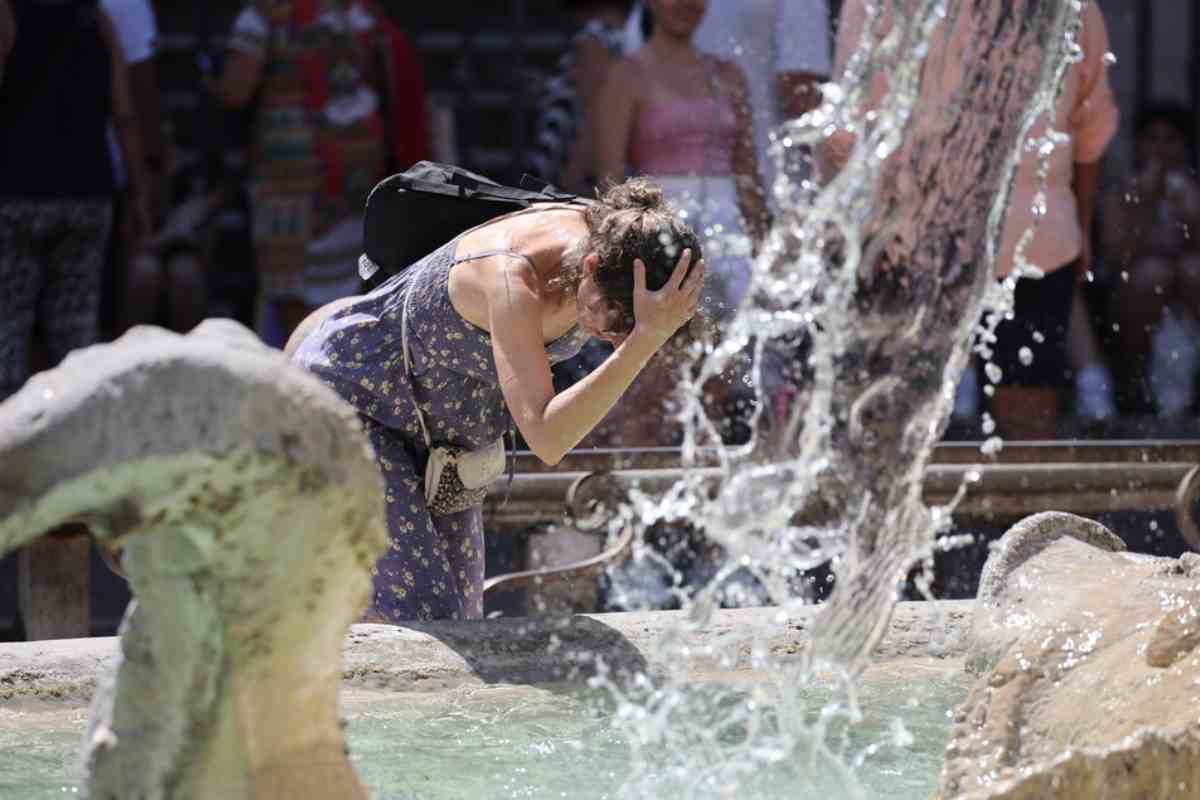 una donna si rinfresca in una fontana