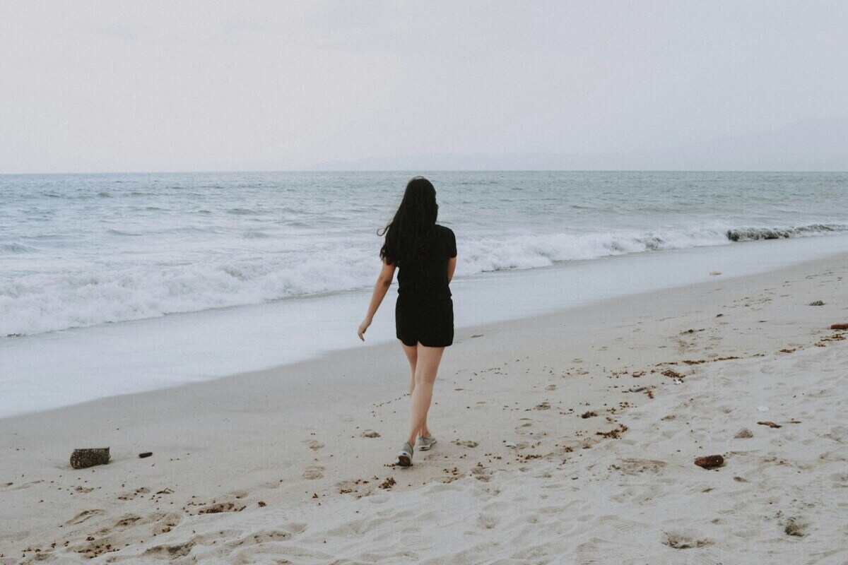 ragazza cammina sulla spiaggia