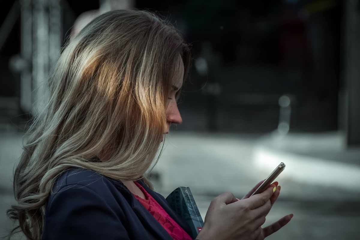 Donna che osserva preoccupata il telefono