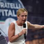 Giorgia Meloni fa la faccia feroce a un comizio di FdI e pensa a Biden