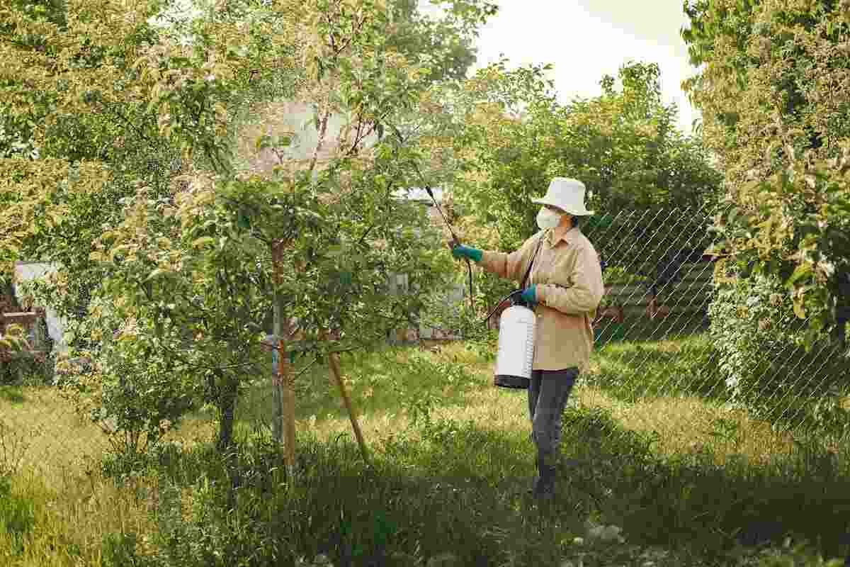 agricoltore spruzza pesticidi