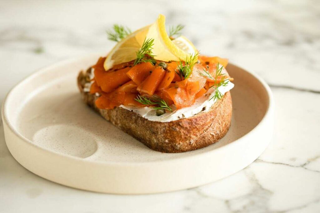 un piatto con una fetta di pane e del salmone affumicato