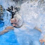 Una persona che si tuffa in piscina