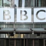 Il simbolo della BBC sopra l'ingresso della sede principale a Londra