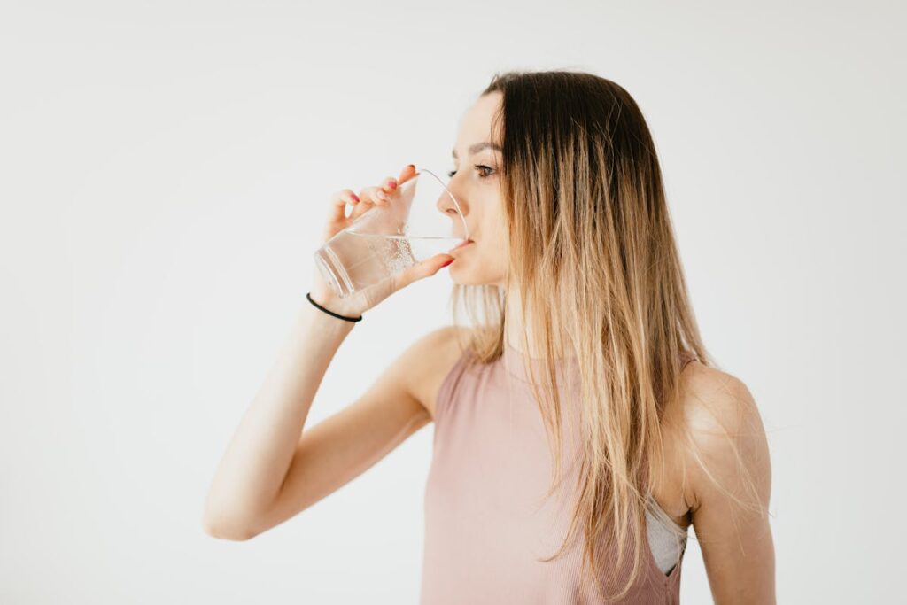 ragazza beve acqua da un bicchiere