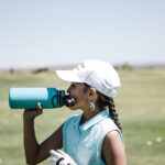 ragazza beve acqua da una borraccia