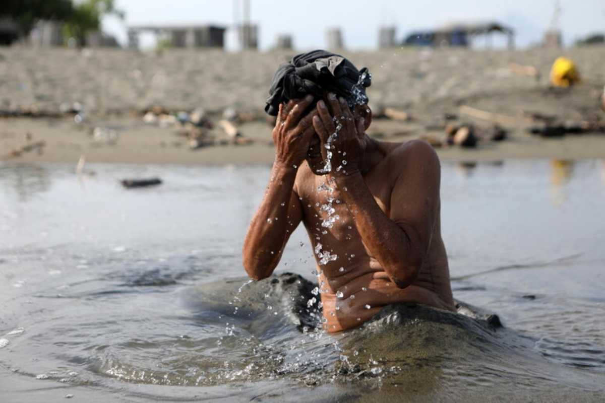 Uomo si tuffa nel fiume per il caldo