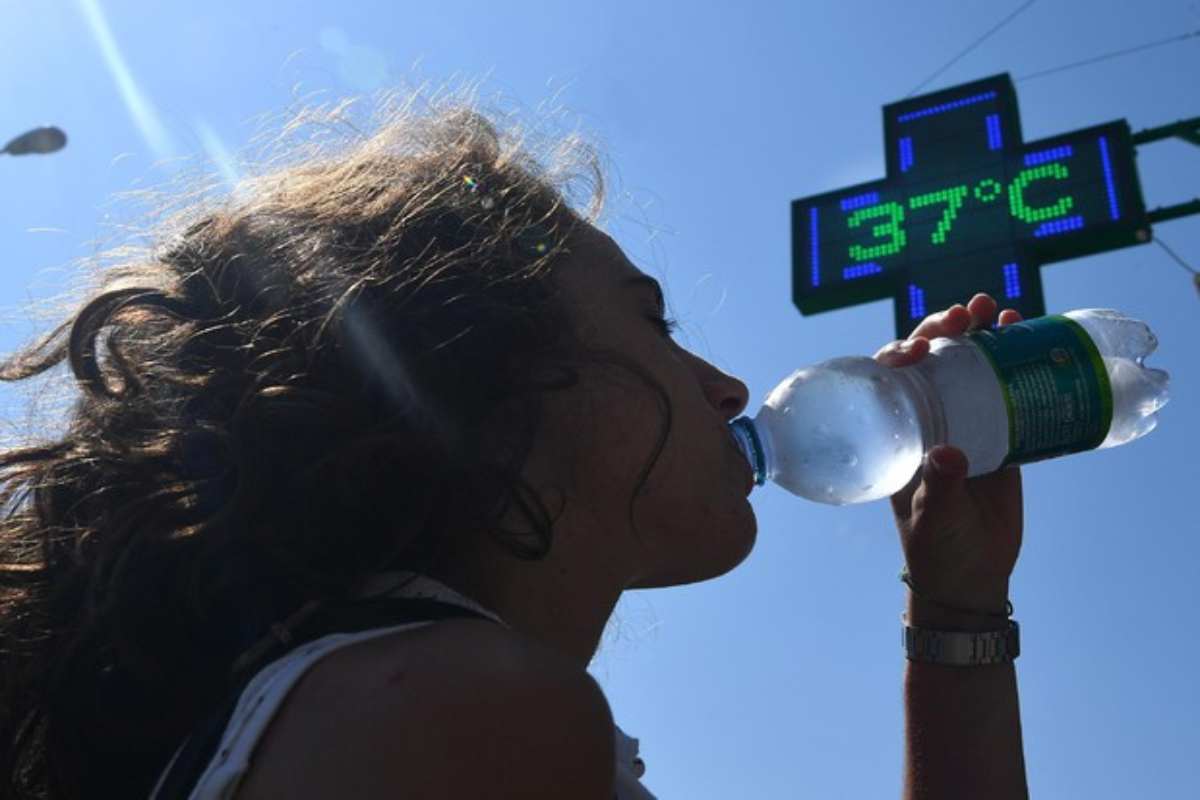 Donna beve acqua per il gran caldo