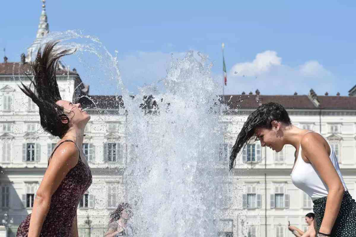 Donne con i capelli bagnati nelal fontana per il caldo