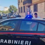 Un'auto dei Carabinieri porta via un uomo