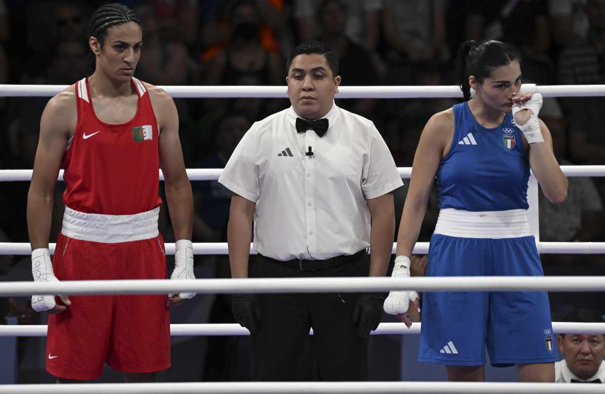 Imane Khelif in rosso, l'arbitro e l'italiana Carini in azzurro sul ring dopo la rinuncia dell'italiana