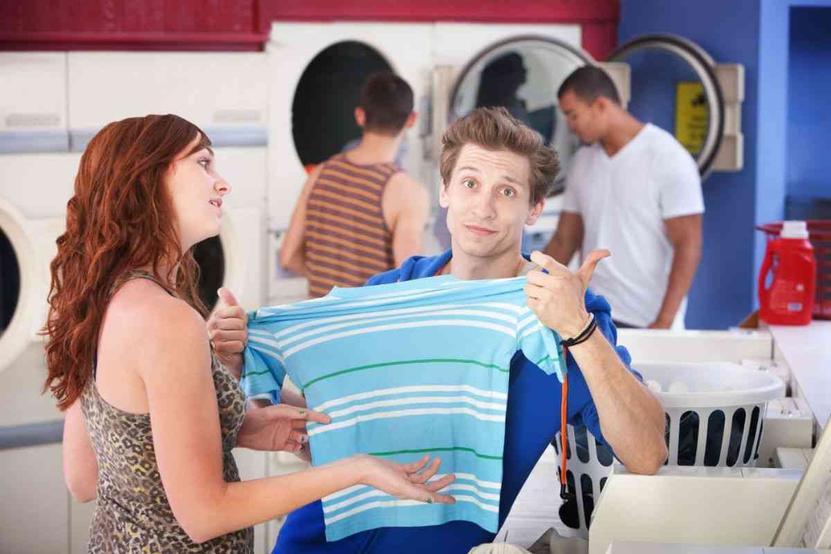 coppia in lavanderia con t-shirt in mano