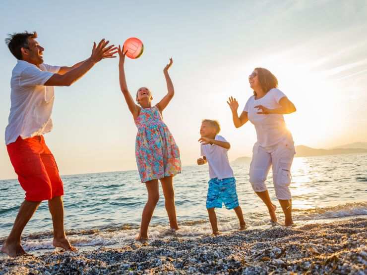 famiglia che gioca a palla in spiaggia