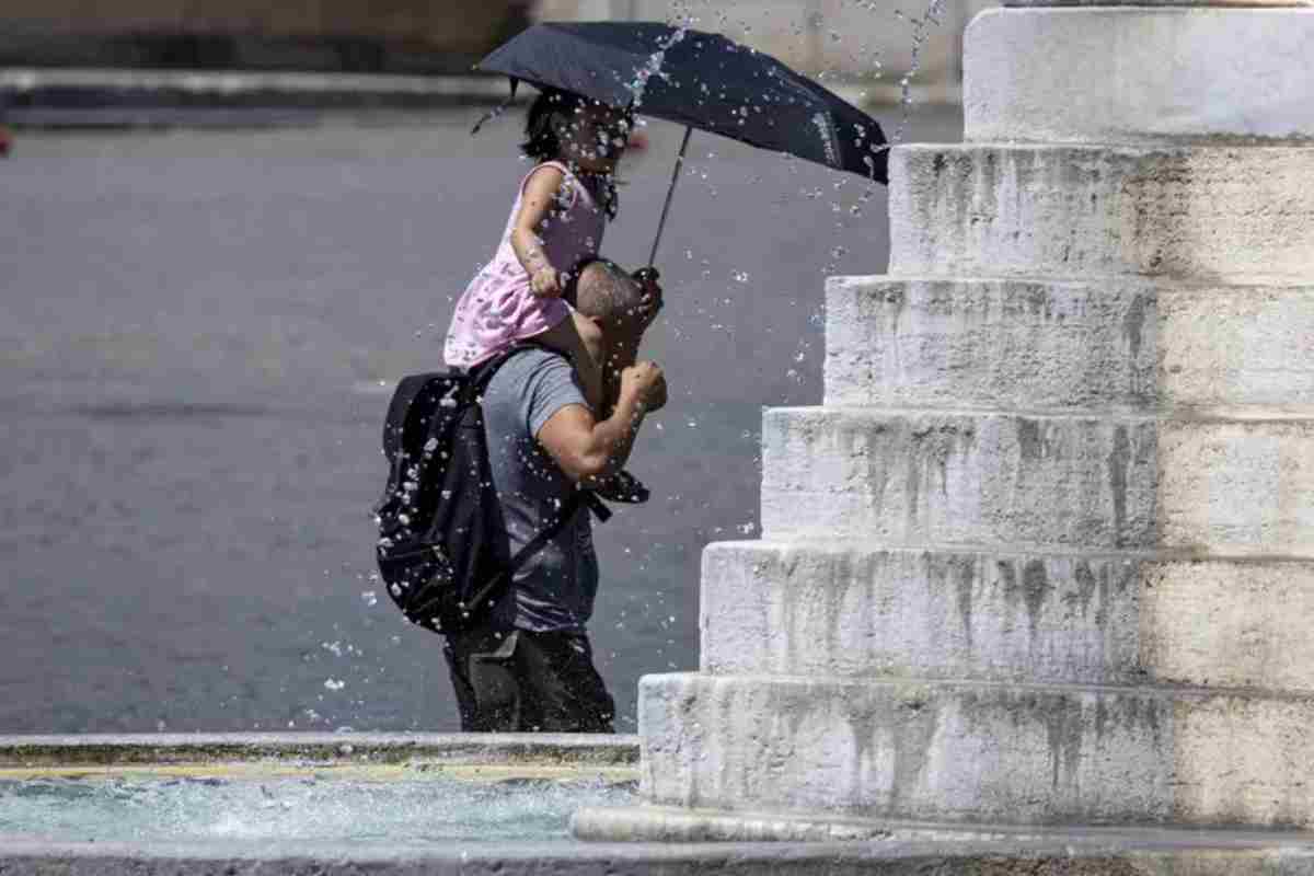 Bimbo e papà con ombrello sotto al sole