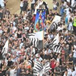 Bandiere e folla al palio di siena: si divertono così, fermi al medioevo