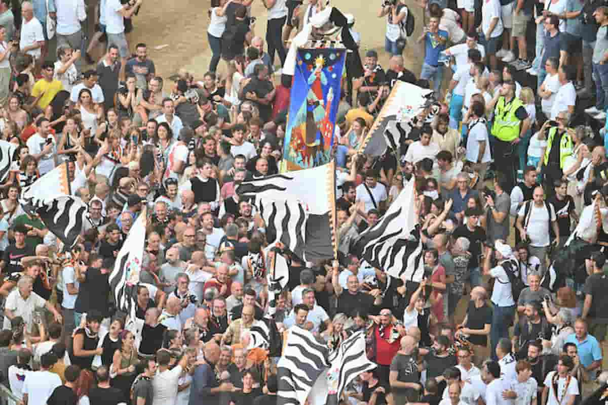 Bandiere e folla al palio di siena: si divertono così, fermi al medioevo