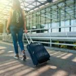 ragazza all'aeroporto con le valigie