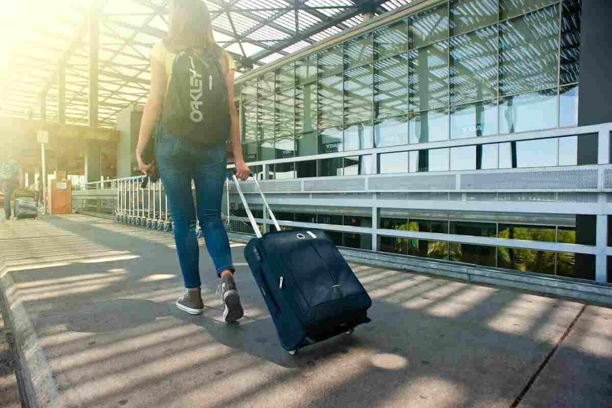 ragazza all'aeroporto con le valigie