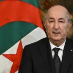 Abdelmadjid Tebboune parla davanti alla bandiera della Algeria