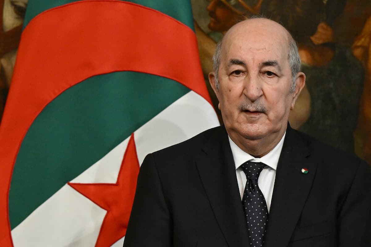 Abdelmadjid Tebboune parla davanti alla bandiera della Algeria