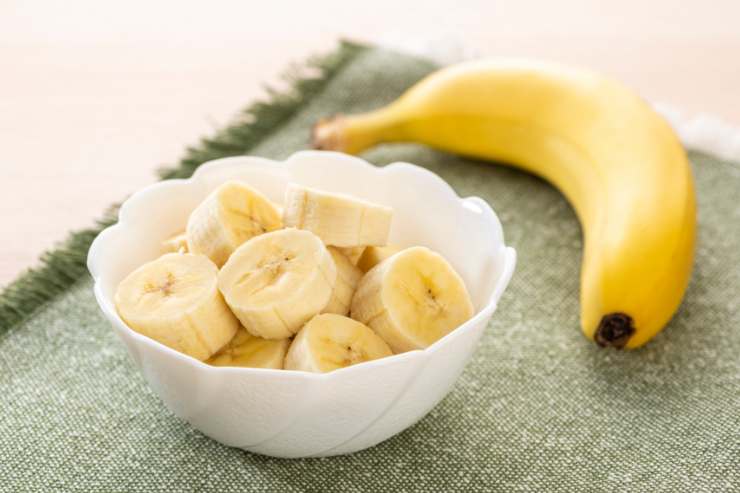 Banana intera e fette in una ciotola