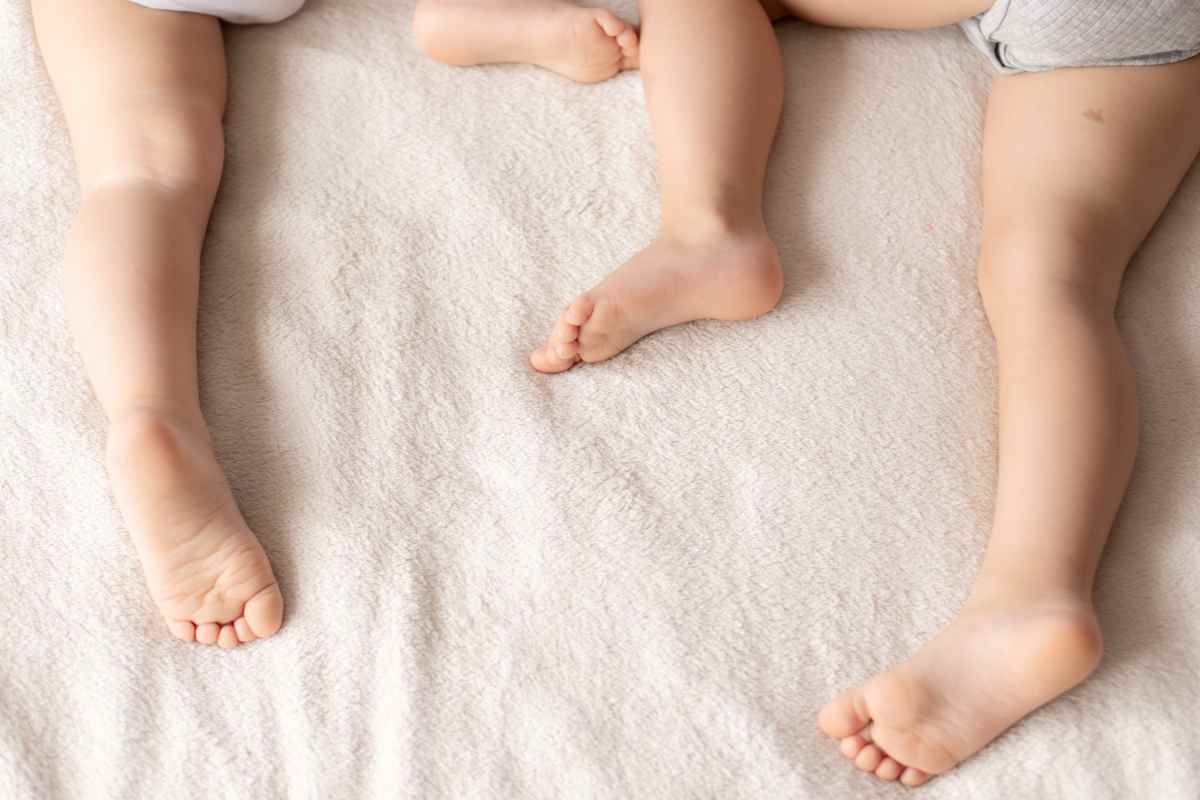 piedini di due bambini sul letto mentre dormono