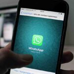 mano con uno smartphone con WhatsApp