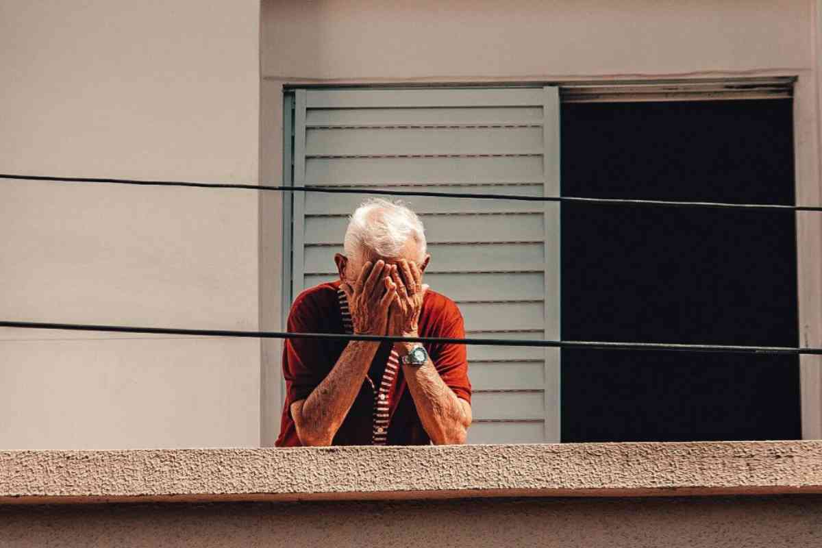 Anziano disperato sul balcone