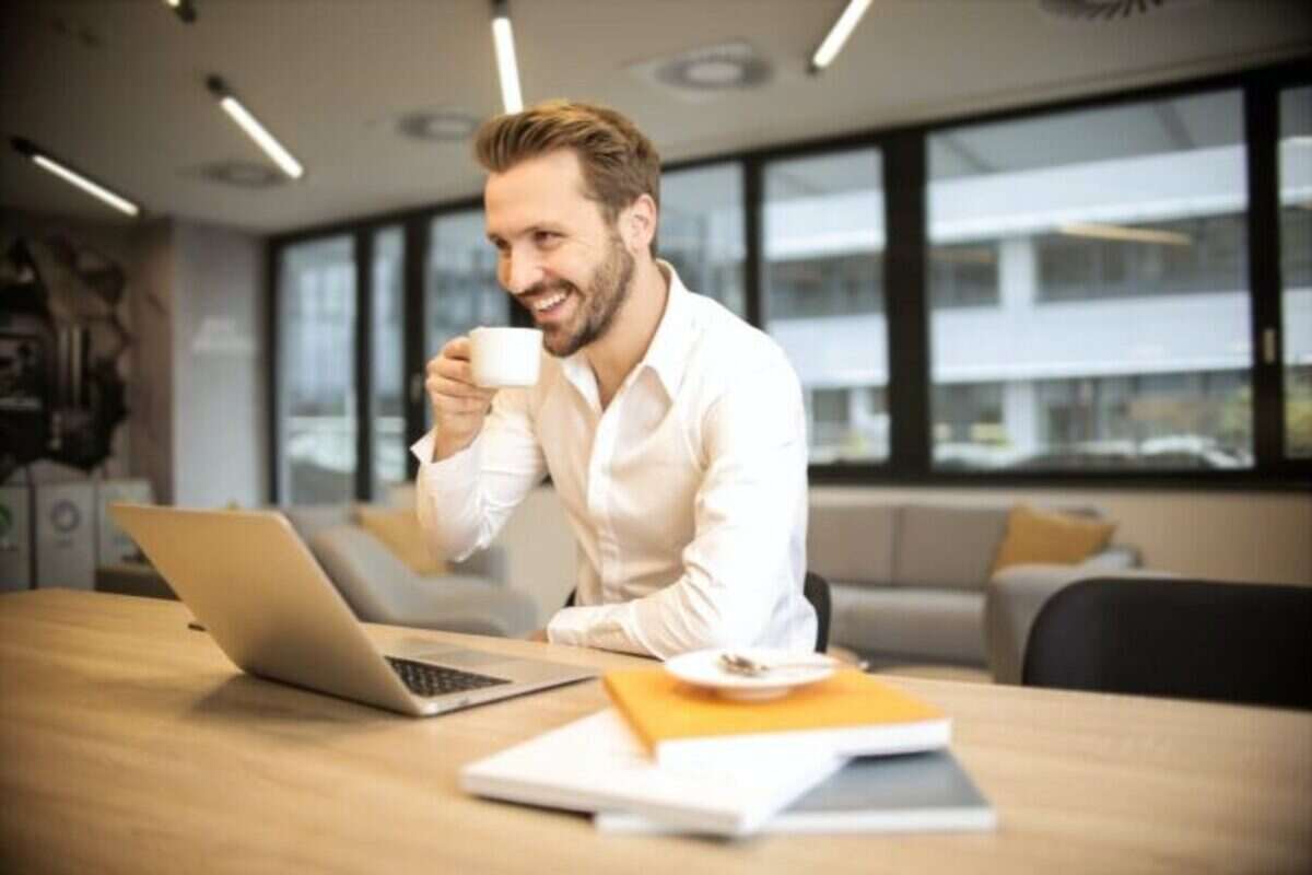 uomo a lavoro con una tazzina di caffè in mano