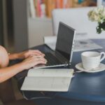 Ragazza al computer con tazza di caffè