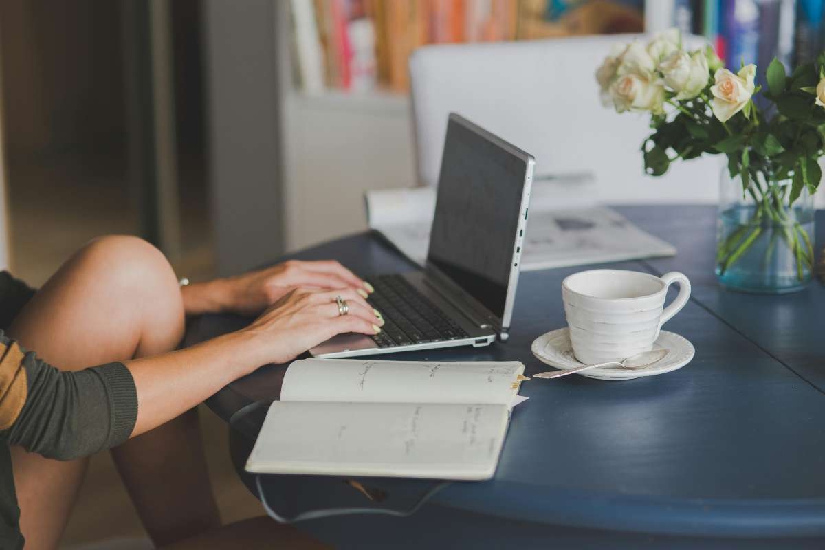 Ragazza al computer con tazza di caffè