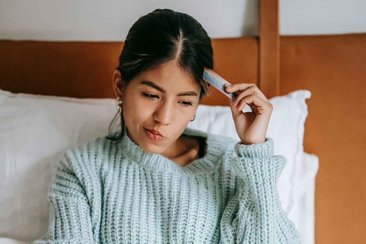 Una donna pensierosa con carta di credito