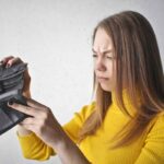 Ragazza che guarda in un portafoglio vuoto