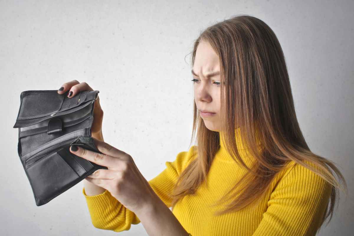 Ragazza che guarda in un portafoglio vuoto