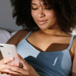 Ragazza con lo smartphone sul letto