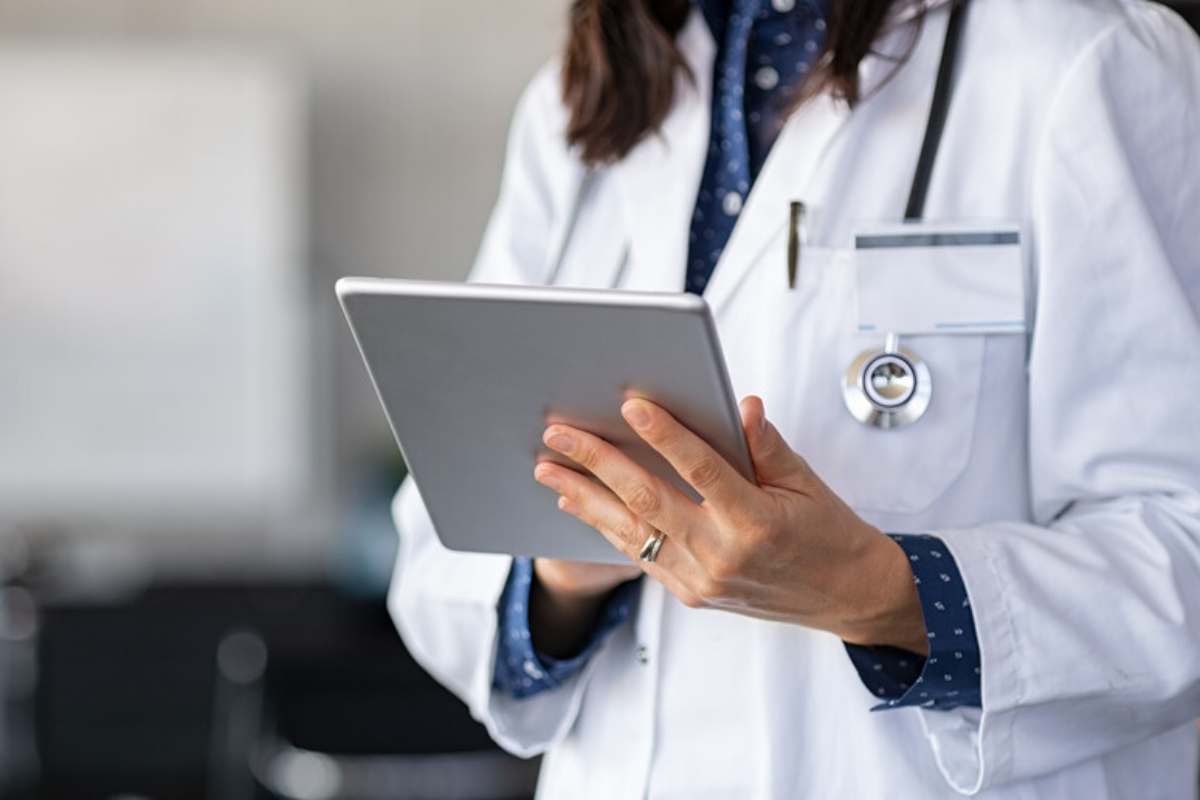 Dottoressa in camice bianco con un tablet in mano