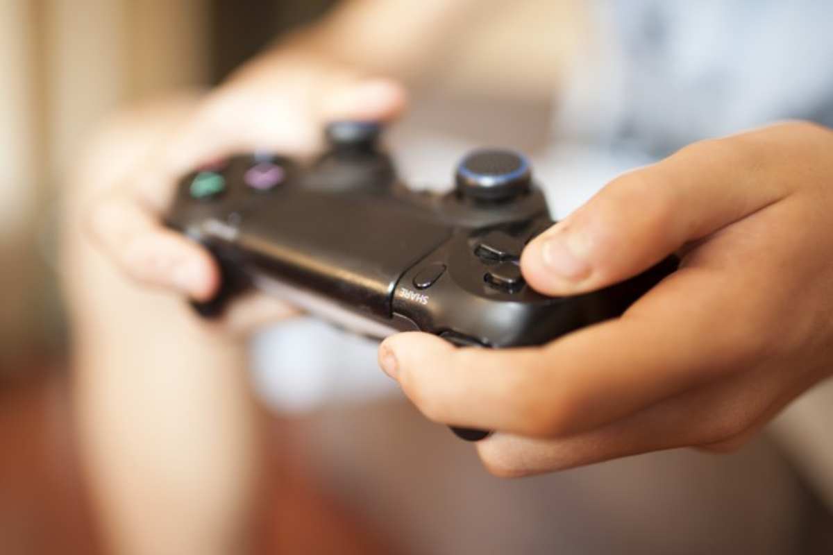 Dettaglio delle mani di un ragazzo con un controller di gioco 