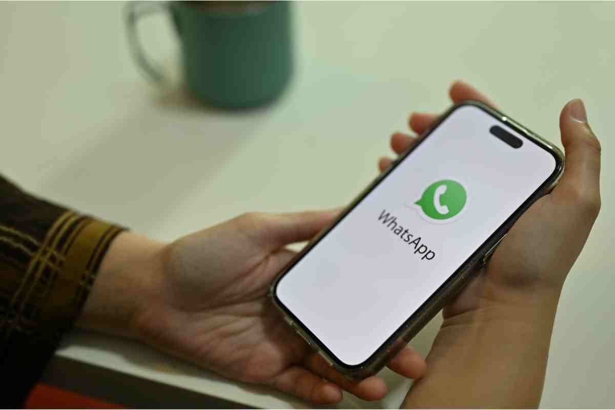 mano tiene smartphone con whatsapp