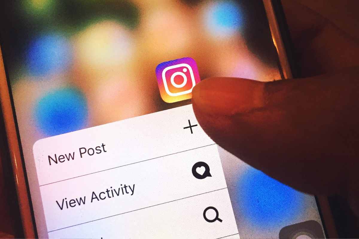 mano regge smartphone con Instagram