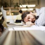 Un lavoratore che dorme in ufficio